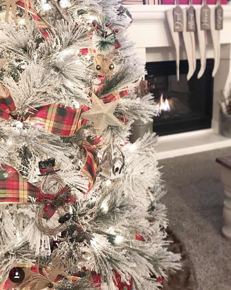A flocked Christmas tree with plaid ribbon and natural accents.