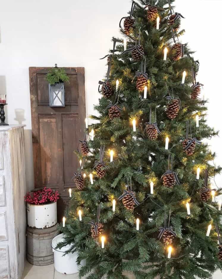 This Christmas tree has what looks like electric candles and pinecones hanging from black and white ribbon.