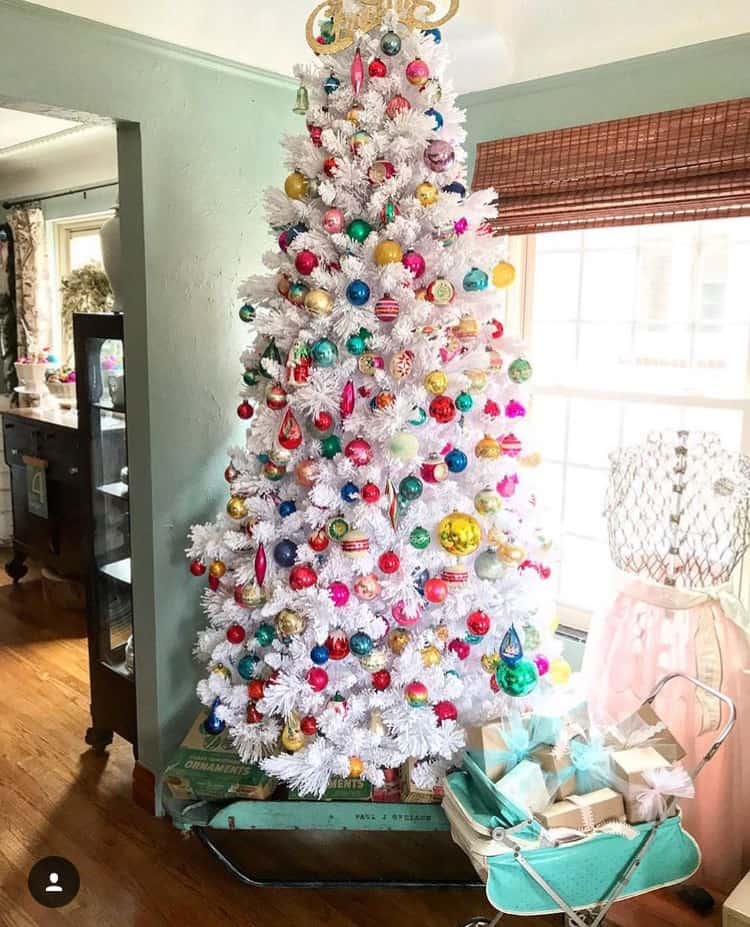 A white Christmas tree with jewel toned ornaments.