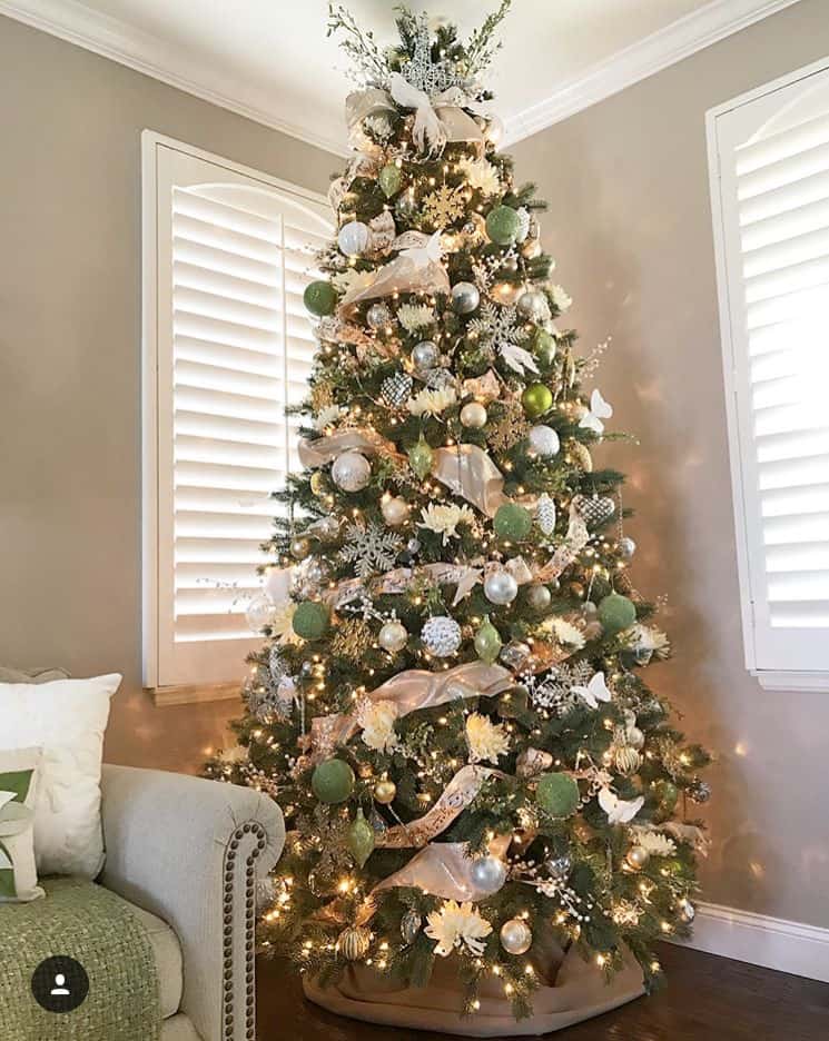 A Christmas Tree with gold ribbon and green and white ball ornaments