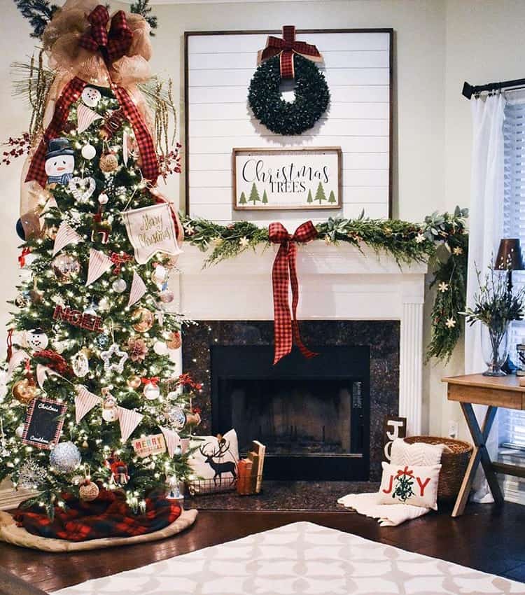 A Christmas tree with tons of different ornaments next to a fireplace.