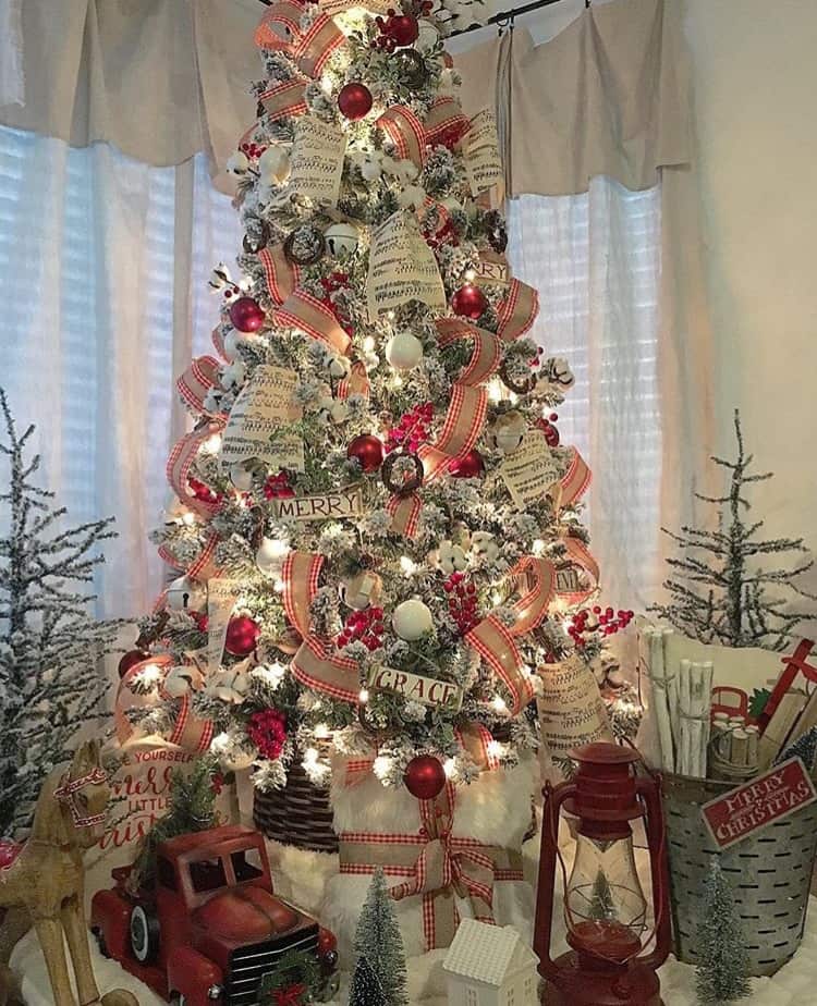 A flocked Christmas tree with sheet music ornaments and plaid ribbon.