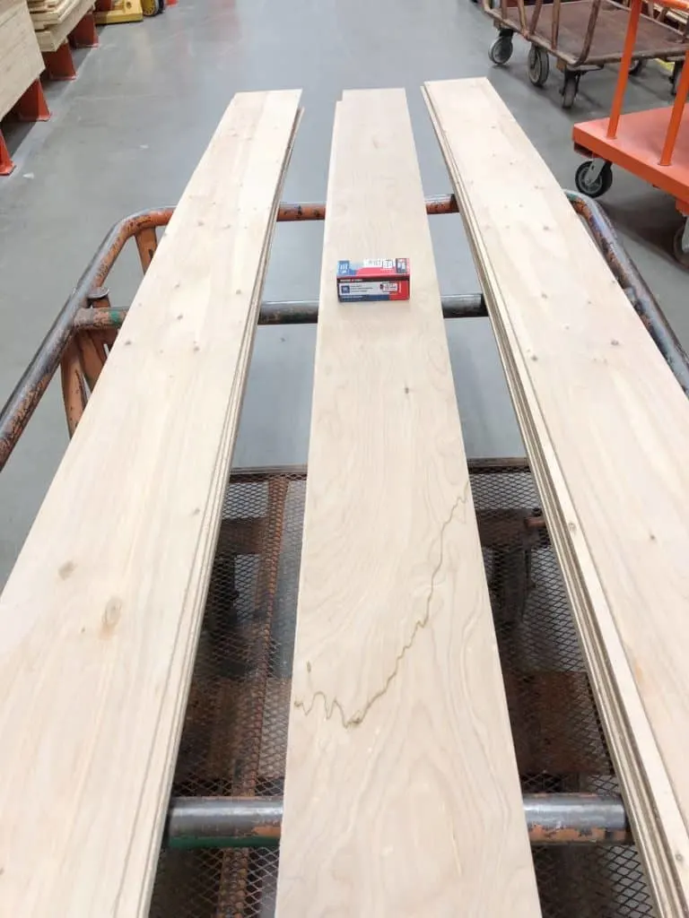 The cut wood for shiplap in the farmhouse laundry room on the cart at Home Depot.