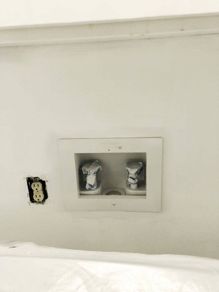 The plastic box in the laundry room that has the connecters for water gets a coat of white paint.