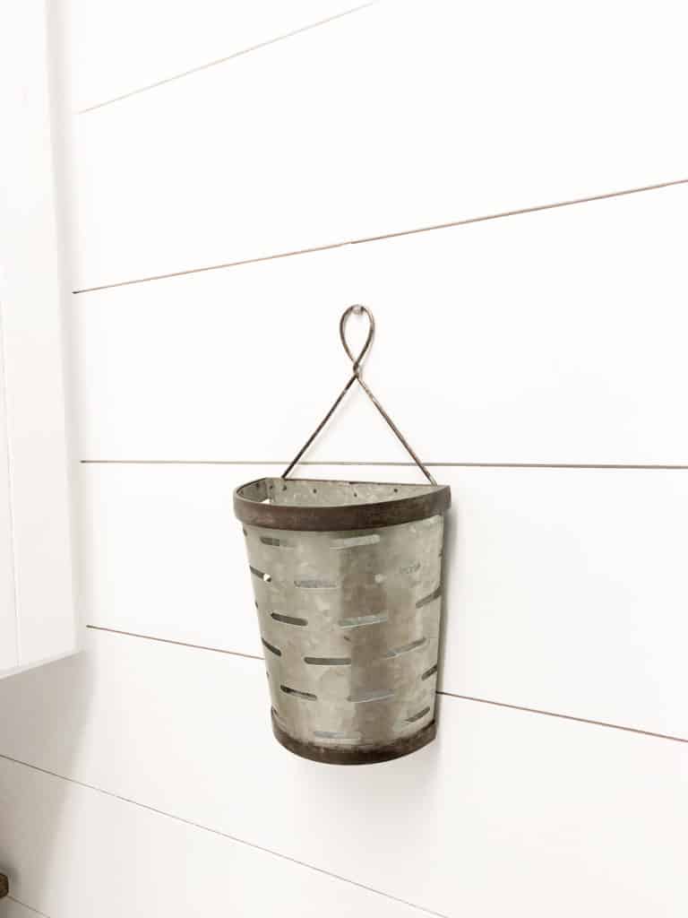 The galvanized bucket hanging on the wall.