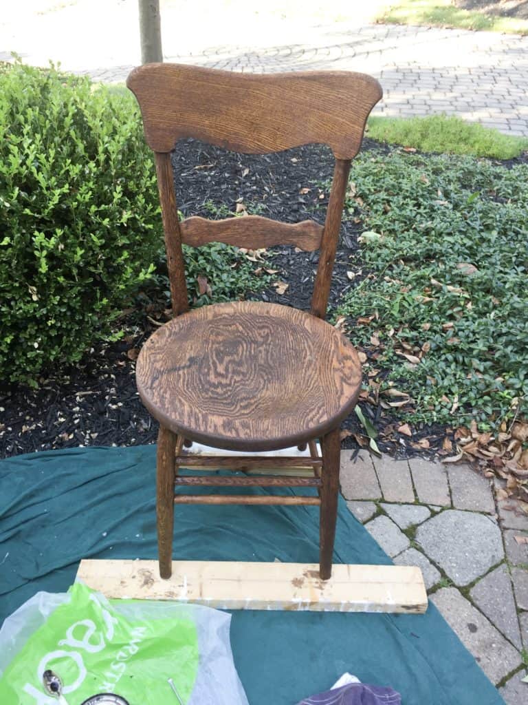 The chair missing both hip rests and being stained.