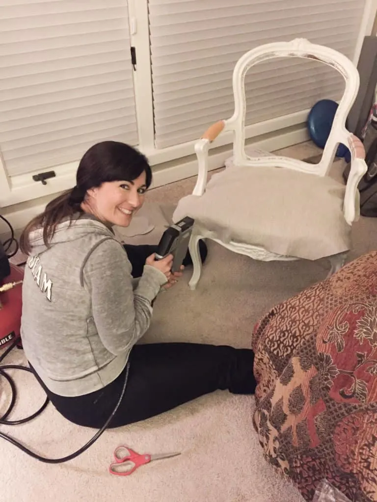 A photo of me reupholstering the seat of the French chair.