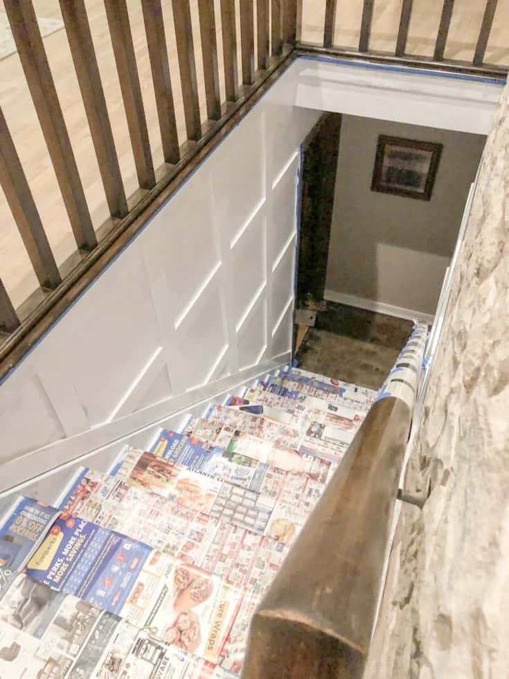 The board and batten stairwell is getting painted and there is still newspaper on the stairs to protect them.