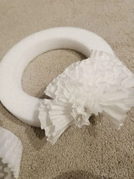 a coffee filter wreath about 25% finished sitting on my carpet