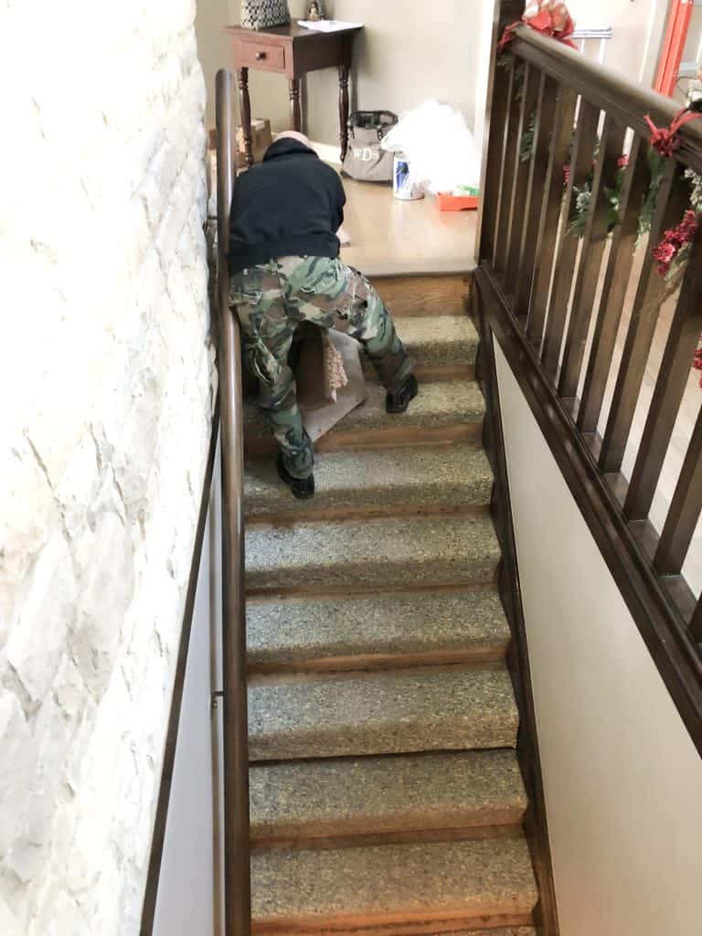 my husband is removing the last piece of carpet and you can see the padding underneath