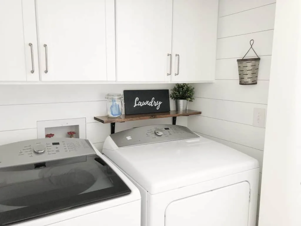 Laundry room with shiplap walls and farmhouse style decor.