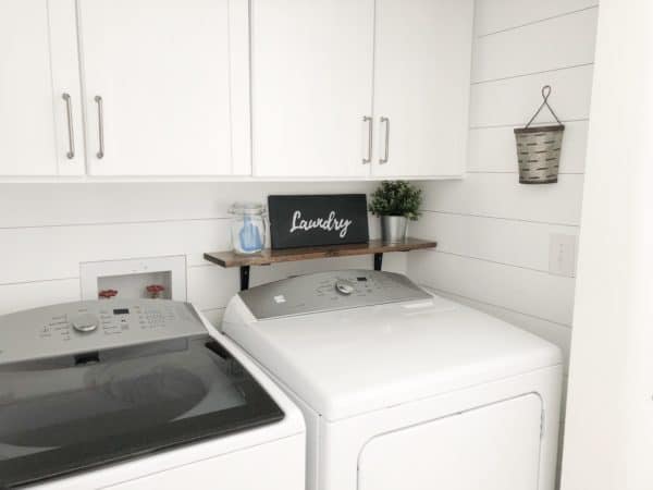 Farmhouse style laundry room with a galvanized bucket on the wall to collect lint.