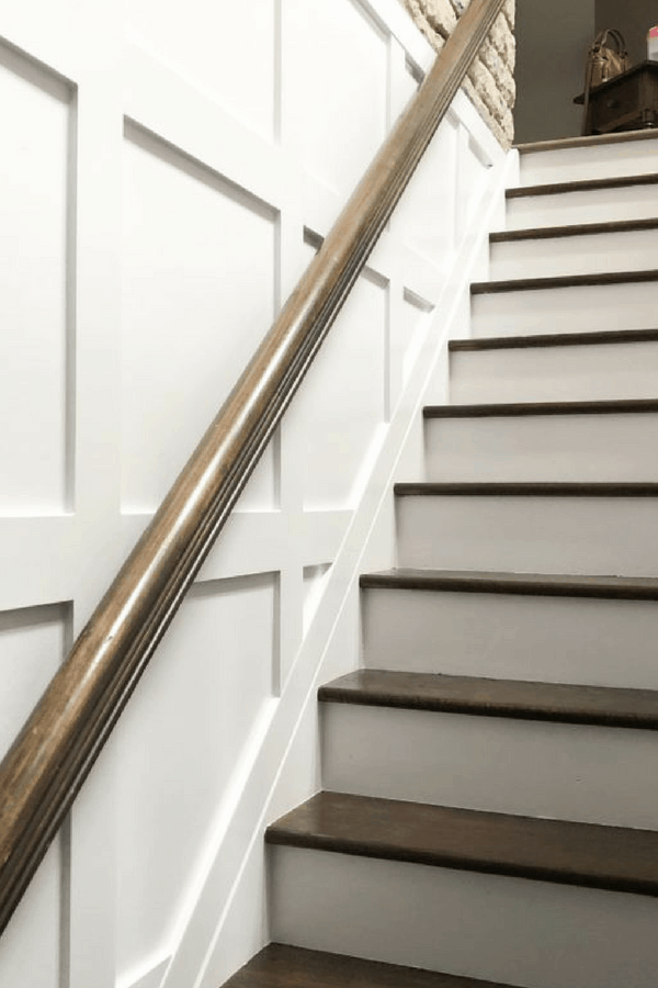 Board and batten box molding painted white and the stairs and hand rail in dark brown.