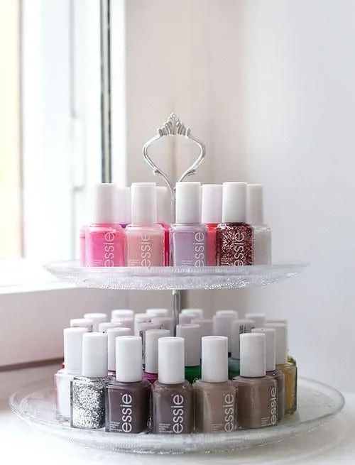 A tiered tray with pretty nail polish on it in rows.