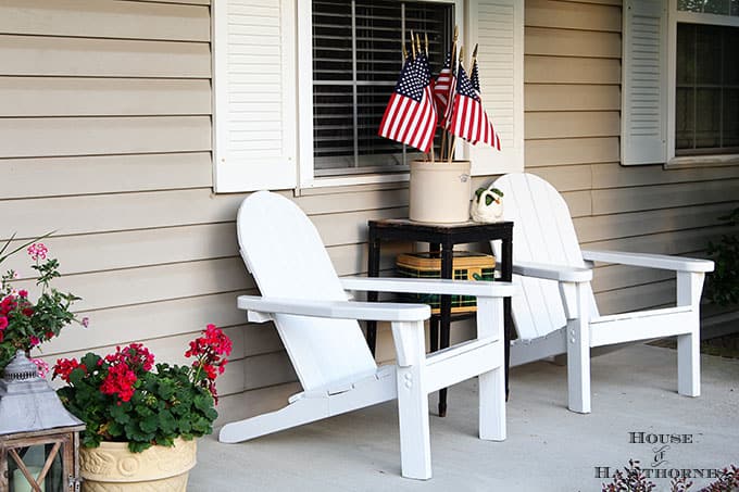 Here we have two adirondac chairs with a side table in between and flags sticking out the top of it.