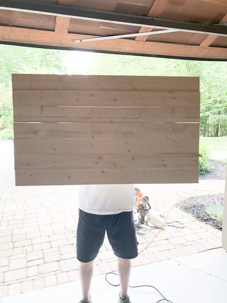 My husband holding up the wood after the braces have been secured.