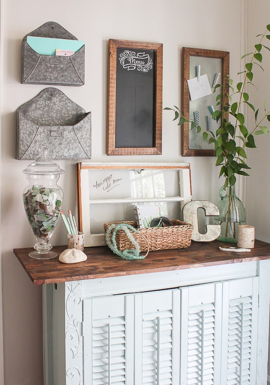 A console table turned command center with organization hanging on the wall above.