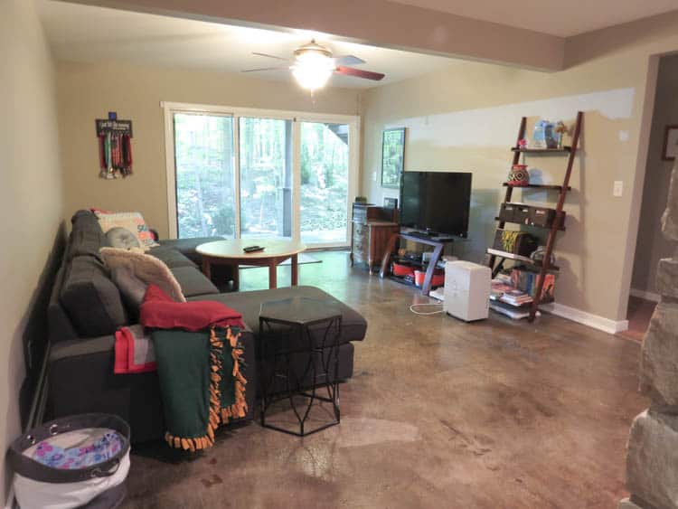 a basement family room with stained concrete and an Ikea Kivik sofa