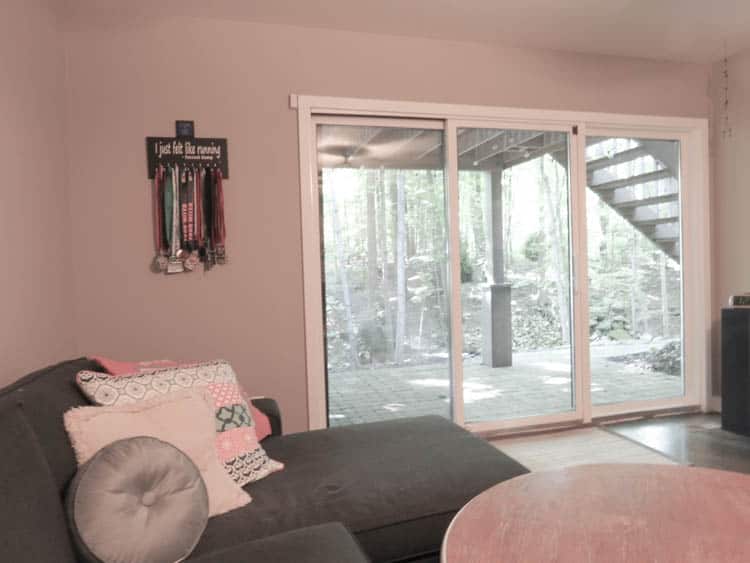 This is a teen hangout room with a dark gray couch, a stained coffeeetable and my daughters running medals hanging on the wall.