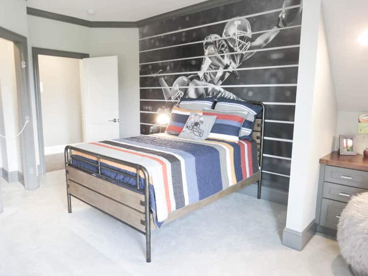 A headboard wall with a mural of a football player in black and white.