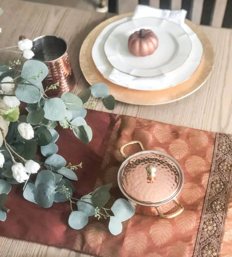 Copper dishes on a fall table runner.