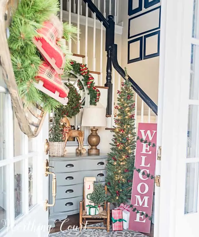 Farmhouse Christmas Decor, an entryway with a christmas tree, welcome sign and lots of wreaths and ribbon
