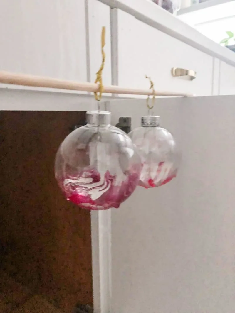 Hanging the DIY marbled ornaments to dry