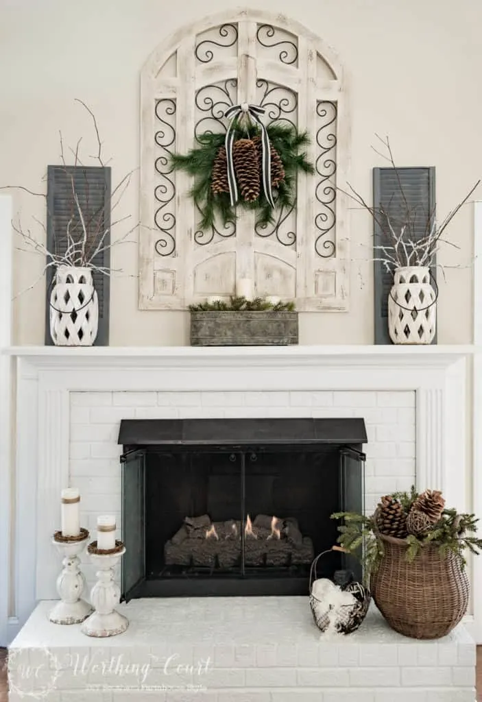 Mantle photo of pine cones, greenery and tree branches for Winter Decor.