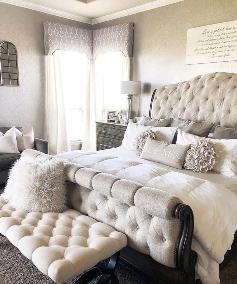 This bedroom is all beige with beige walls and a beige tufted headboard, with a tufted footboard and bench.