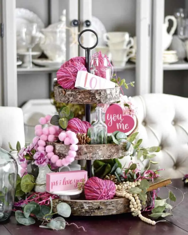 Tiered tray with pink accents and farmhouse signs saying love, you and me and ps I love you.