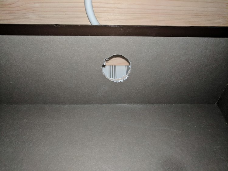 Cutting a hole in the back of the dresser drawer for cords to charge your items inside the drawer and not on top.