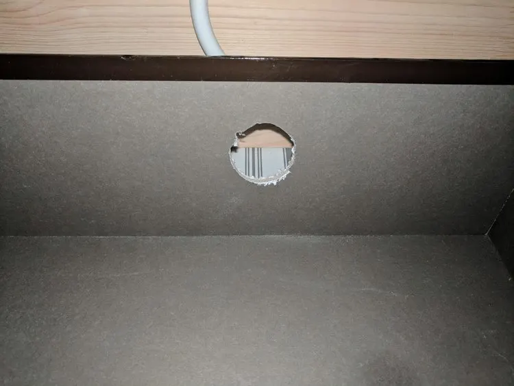 Cutting a hole in the back of the dresser drawer for cords to charge your items inside the drawer and not on top.