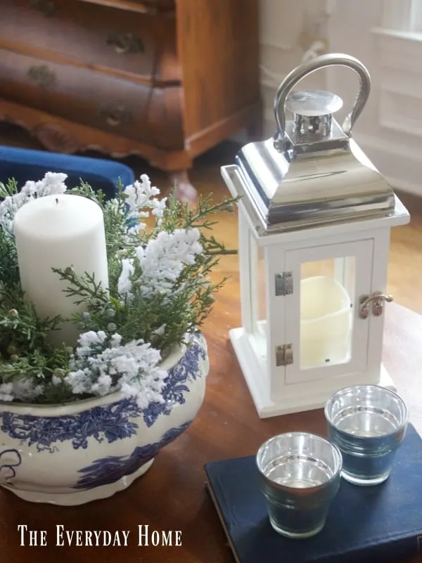 A beautiful vignette with white candles, flowers, and a white lantern.