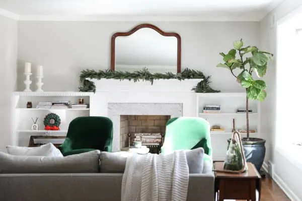 Agreeable Gray Greige Paint Color in a family room with a white mantel on a fireplace and built-ins on either side.