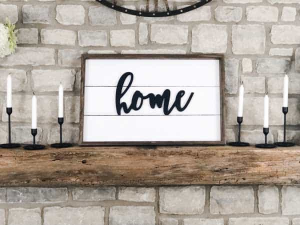 A shiplap sign on my mantel made using shiplap and the word home on it.