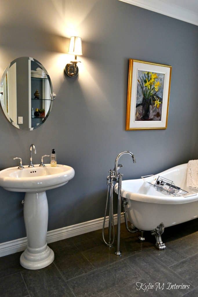 Dior Gray in a bathroom with a white claw foot tub and pedestal sink.