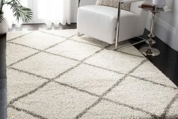 A white shag rug with a gray diamond pattern.