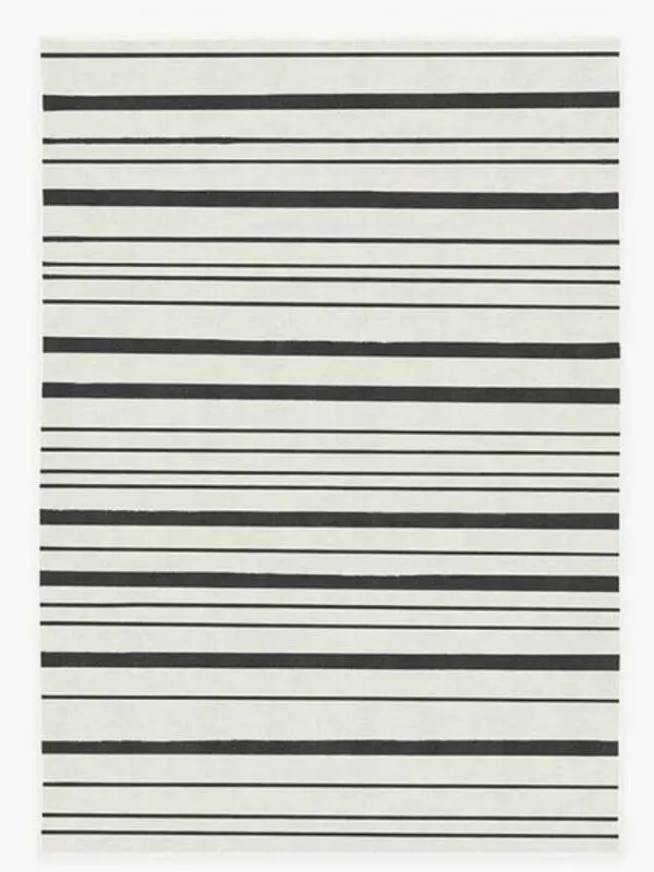 A white rug with black stripes of different widths.