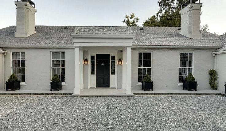 The exterior of a ranch style home painted in Revere Pewter.