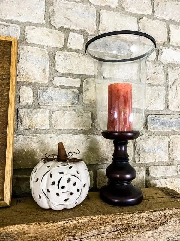 The ceramic white pumpkin and an orange candle in a large urn, fall mantel decorating tips.
