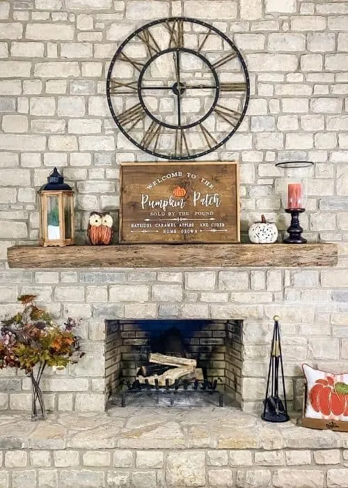 A front view of my fireplace with a sing, owl, pumpkin candle and lantern on the mantel.