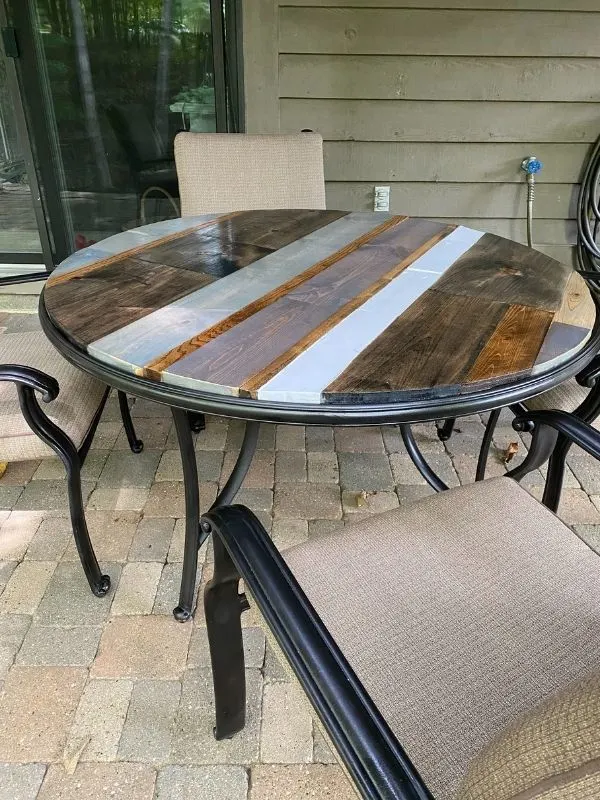 The finished table top on the newly spray painted base with the chairs.