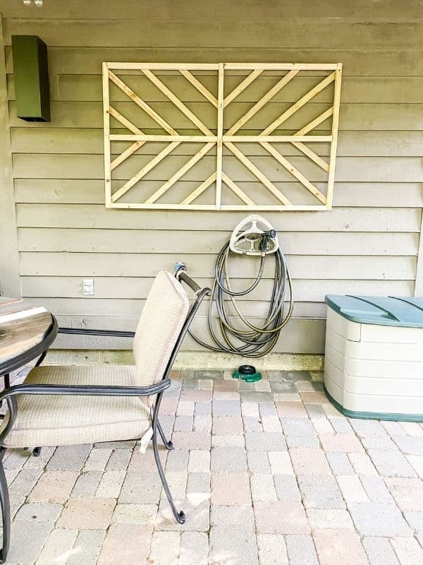 DIY Outdoor Wall Art hanging on the house above where the hose reel is.