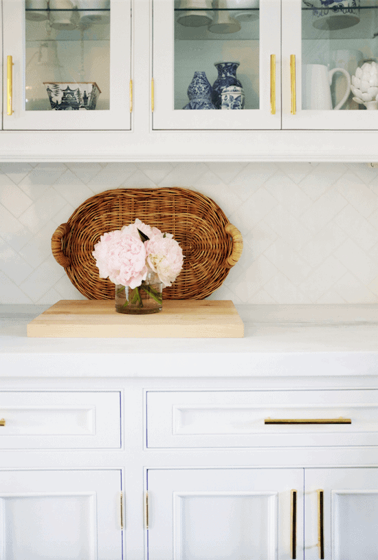 A white kitchen with gold pulls on both the drawers and cabinets.