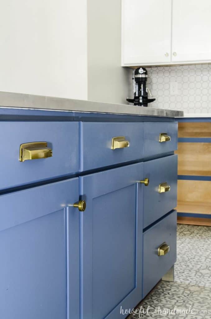 A blue island with gold cabinet hardware.