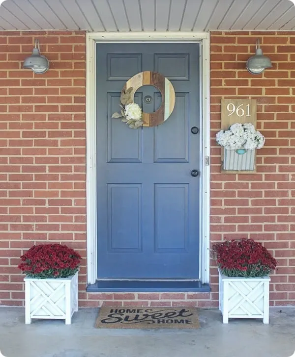 A red brick home with a front door that is cobalt blue.