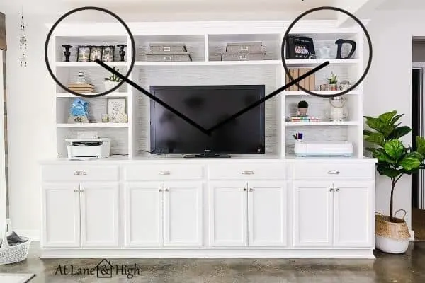 This highlights the dark decor items on either side of the tv and how they balance each other.