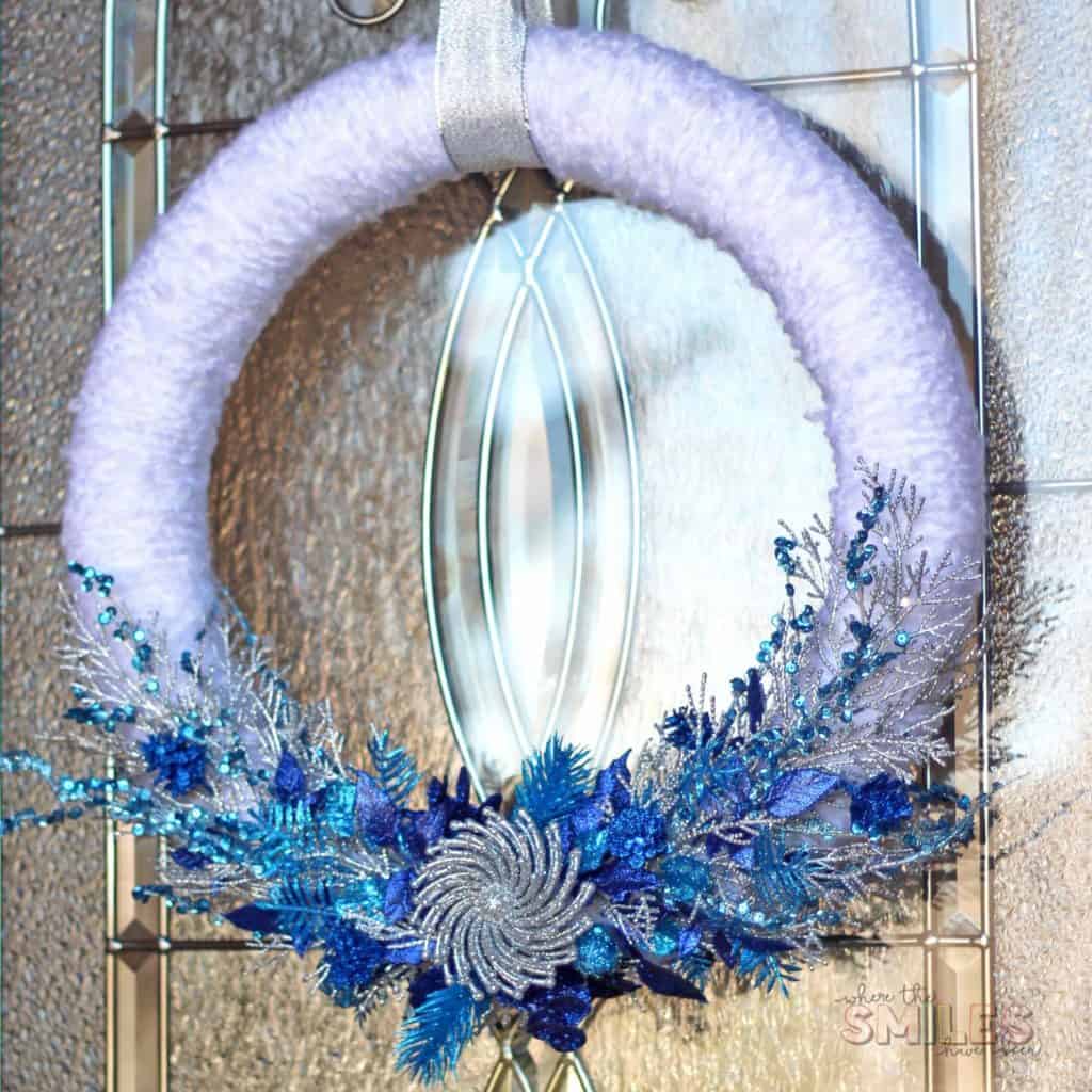 A white wreath with sprigs of glue and turquoise on it.  Very glamorous.