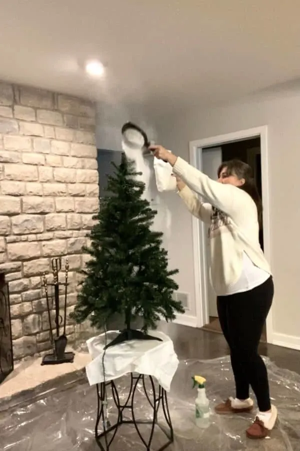 Me using a sifter to spread flocking powder on the tree.