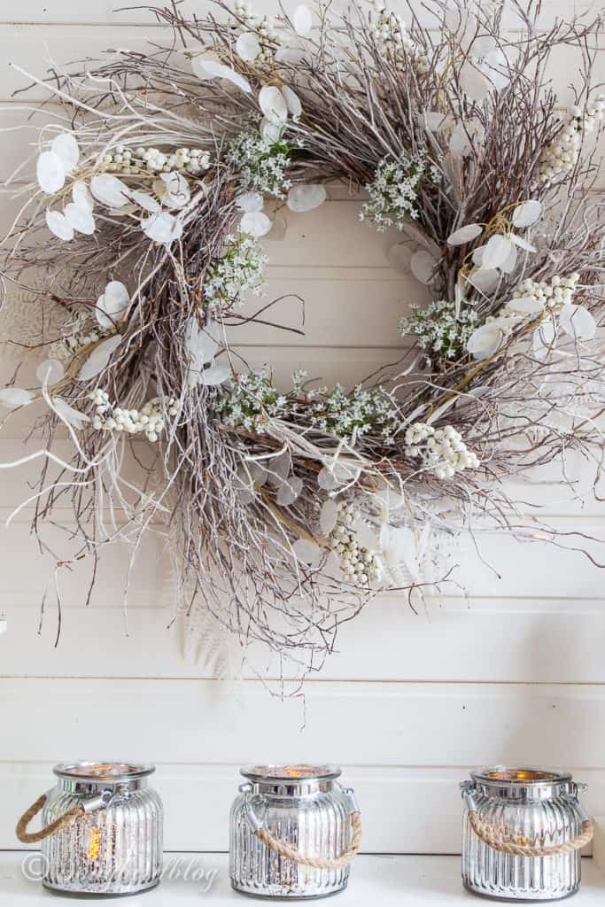 A grapevine wreath with other elements of nature in it in white.